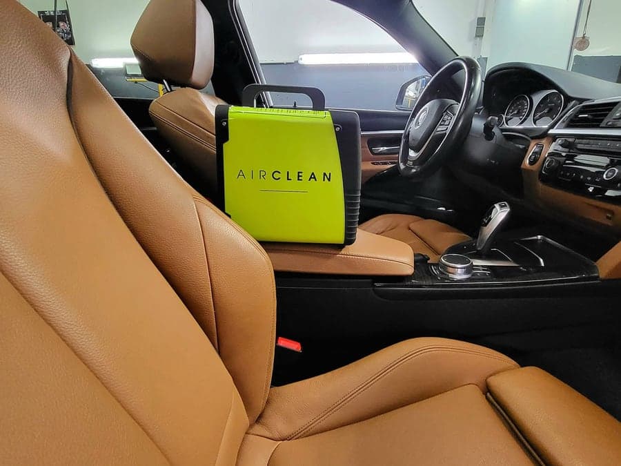 Ozongerät AirClean auf dem Ledersitz eines BMW-Innenraums