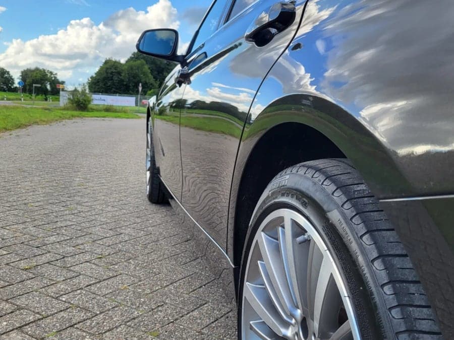 Schwarzer BMW mit spiegelndem Lack und Alufelge im Seitenprofil