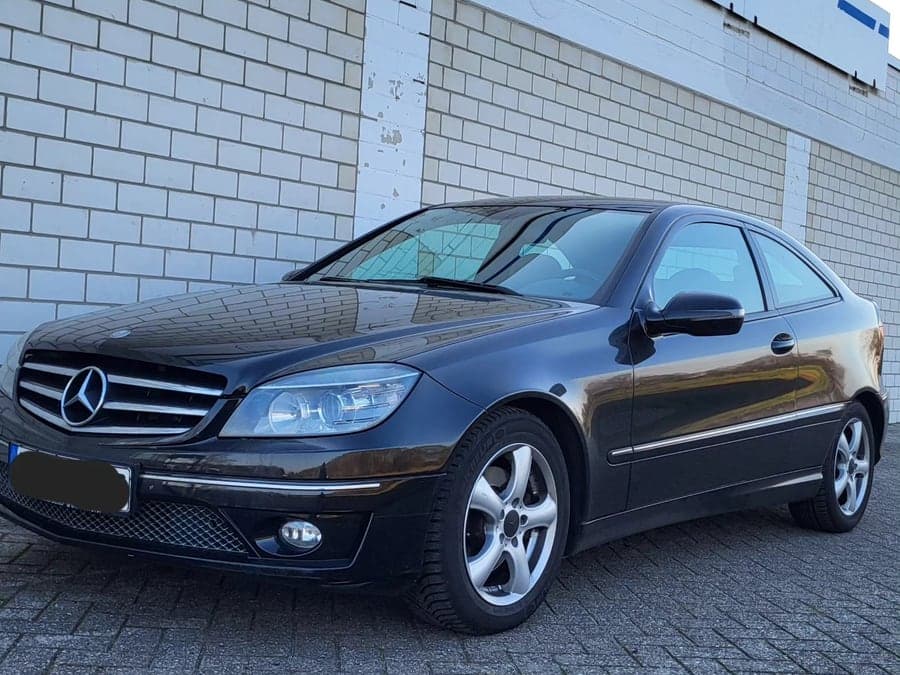 Schwarzes Mercedes Coupé von schräg vorn auf dem Hof