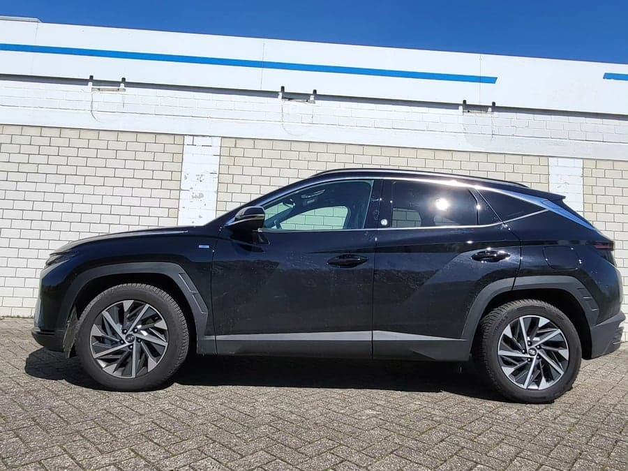 Schwarzer Hyundai Tucson im Seitenprofil vor blauem Himmel