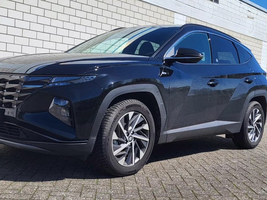 Schwarzer Hyundai Tucson von schräg vorn in der Sonne